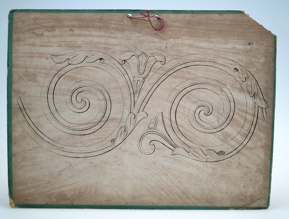 Fem plansjer av papp med ulikt motiv. Det er grønne papplater med to hull for oppheng, Tre av dem har bomullsbånd for oppheng, en har rød hyssing. På papplatene er det limt på papir med trykt motiv. På pairet er det tegnet rutemønster i bakgrunnen. Dette er trolig gjort for å lette arbeidet med å kopiere/tegne av motivet. på noen av plansjene er det også hull etter bruk av passer. Motivene er følgende: 
01: Løve med vinger (også kjent som Markusløven)
02: Akantusranke
03: Akantusranke
04: Detalj på ranke
05: Dobbel akantusranke
06: Løve