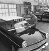 Huskvarna glasmästeri 8 mars 1963, Harry Andersson står vid en Ford och håller i bilens framruta.