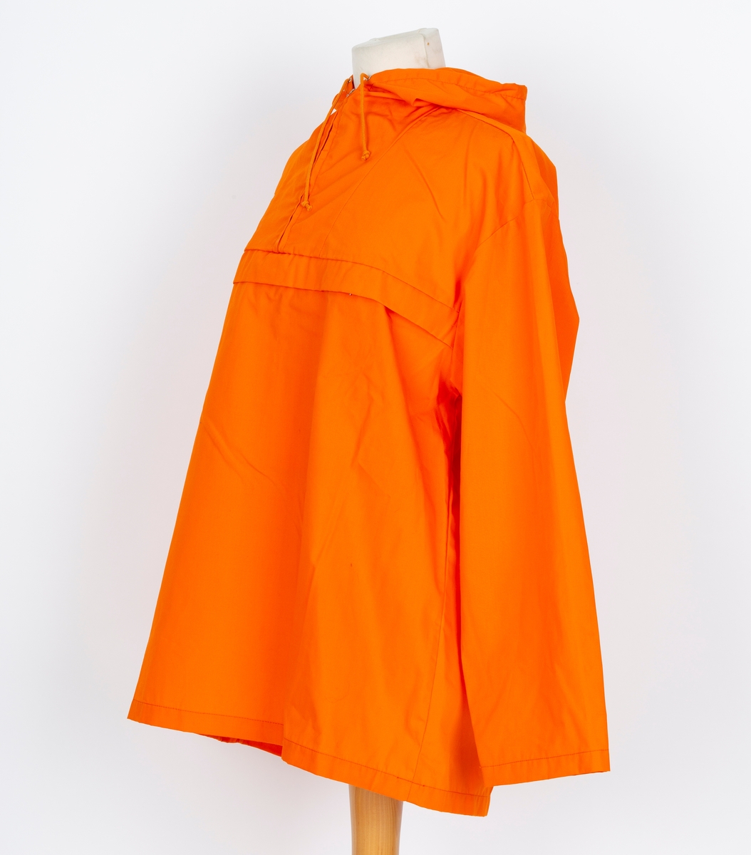 Anorakk. Hette. Brystlomme. Påsydd blått og hvitt merke  merke: Norjamb 75 14. woeld jamboree. menber made of Swiss Polyester
Givers ektemann Per Ottesen var disponent for Speidersport og hadde leveranser av utstyr og merkeklær til deltakere på leiren
