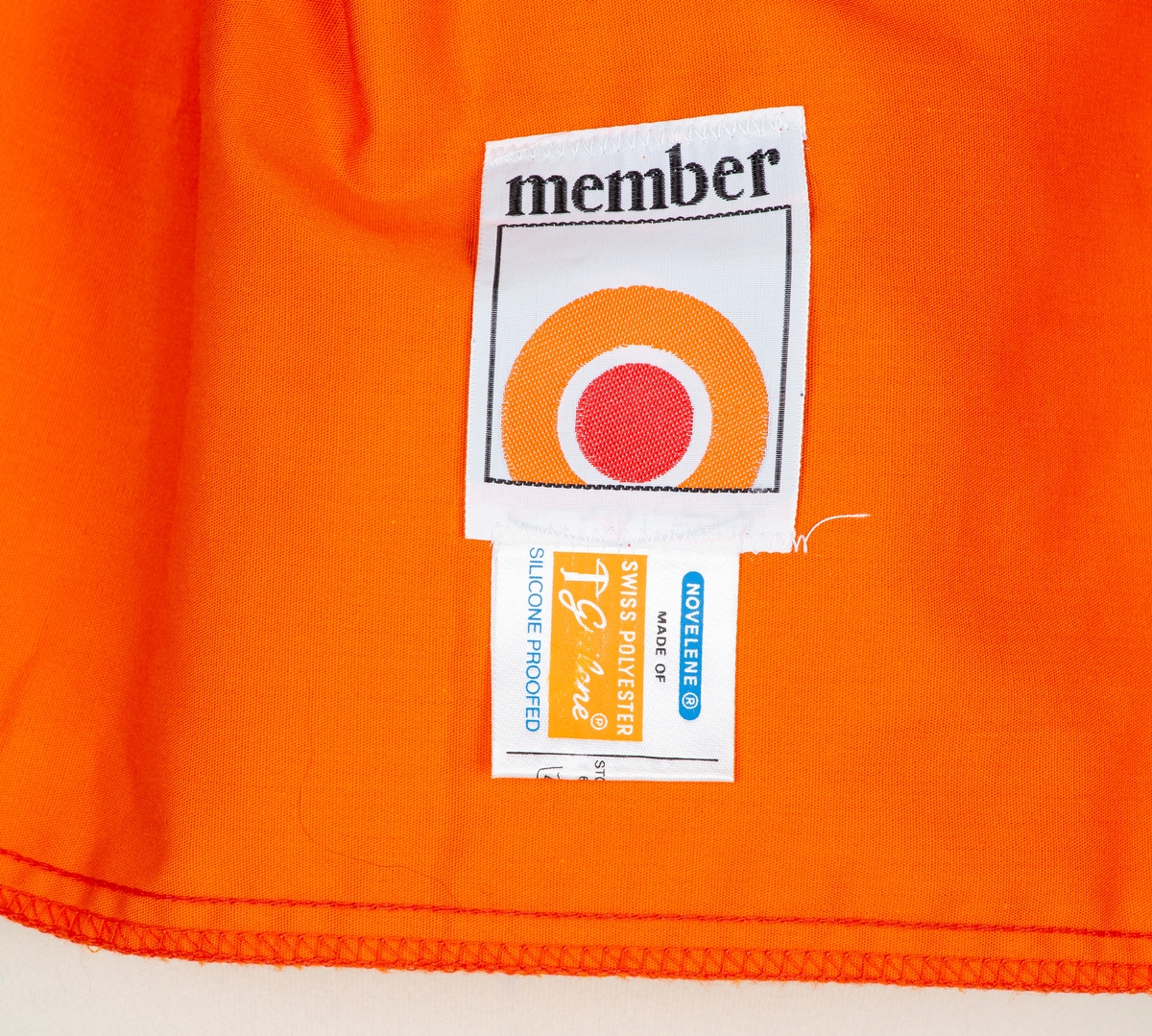 Anorakk. Hette. Brystlomme. Påsydd blått og hvitt merke  merke: Norjamb 75 14. woeld jamboree. menber made of Swiss Polyester
Givers ektemann Per Ottesen var disponent for Speidersport og hadde leveranser av utstyr og merkeklær til deltakere på leiren