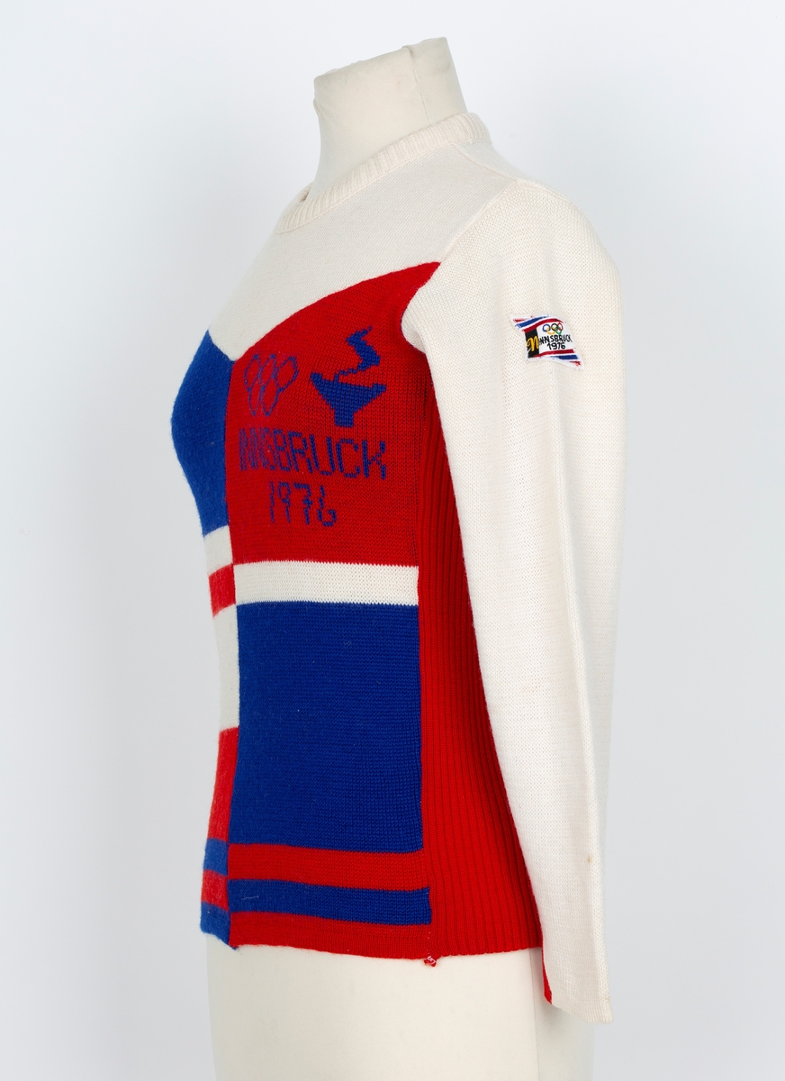 Genser. OL genser fra Insbruck 1976. Lange ermer. Rund hals. Hvit, rød og blå i felter og stripet.
Merke med 5 olympiske ringer og Insbruck 1976 påsydd ermet.