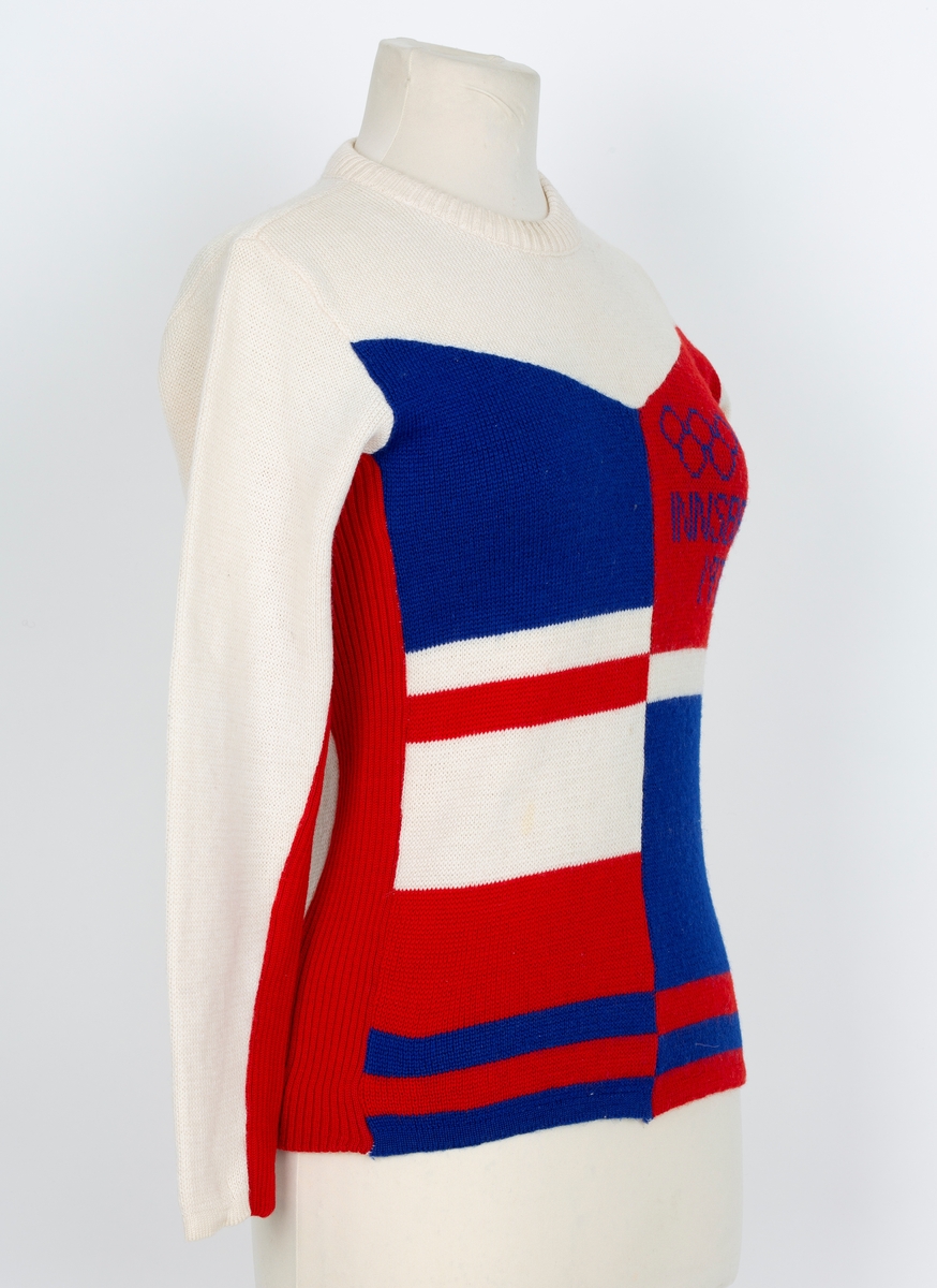 Genser. OL genser fra Insbruck 1976. Lange ermer. Rund hals. Hvit, rød og blå i felter og stripet.
Merke med 5 olympiske ringer og Insbruck 1976 påsydd ermet.