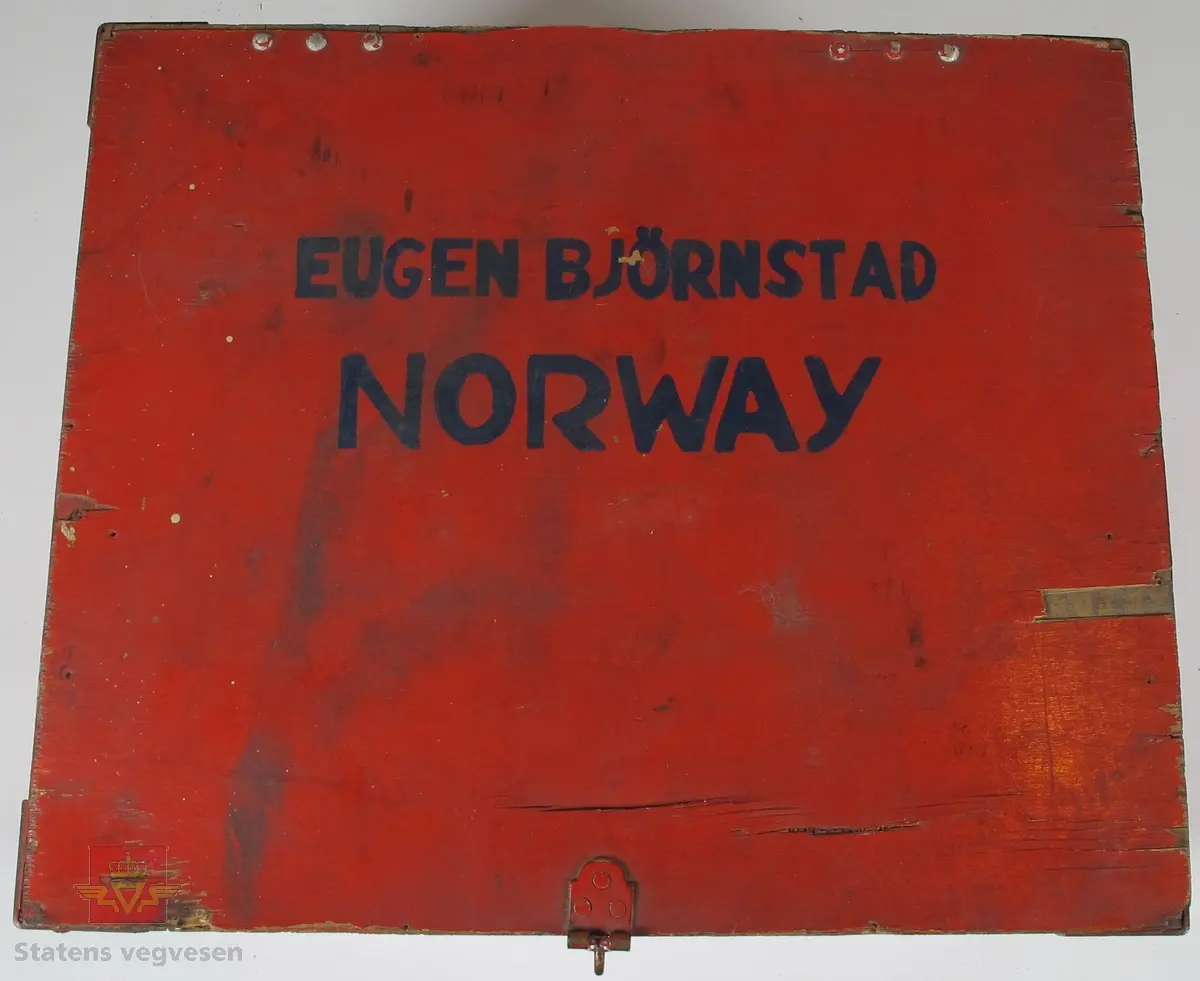 Hjelm med norsk profilering som består av flere lag/skall. De ytterste lagene er laget av tre og innsiden er laget av kork. Det er lagt skinn og tekstil som en myk barriere mellom hjelmen og hode. Med hjelmen tilhører det 2. stk. Visir laget av skinn og plast som er pakket inn i stoff for beskyttelse. Det hele er lagret i en medfølgende rød eske laget av tre og papp på innsiden.