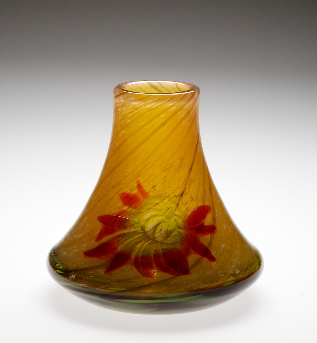 "Dahlia", formgiven av Betzy Ählström. Utförd i tekniken marqueterie de verre.
Art.nr. # 59. Dekor bestående av blomma i rött och ljusgrönt, mot en honungsgul botten med vridna tunna bruna linjer. Blomdekoren är förstärkt genom slipning.

Inskrivet i huvudkatalogen 1942.