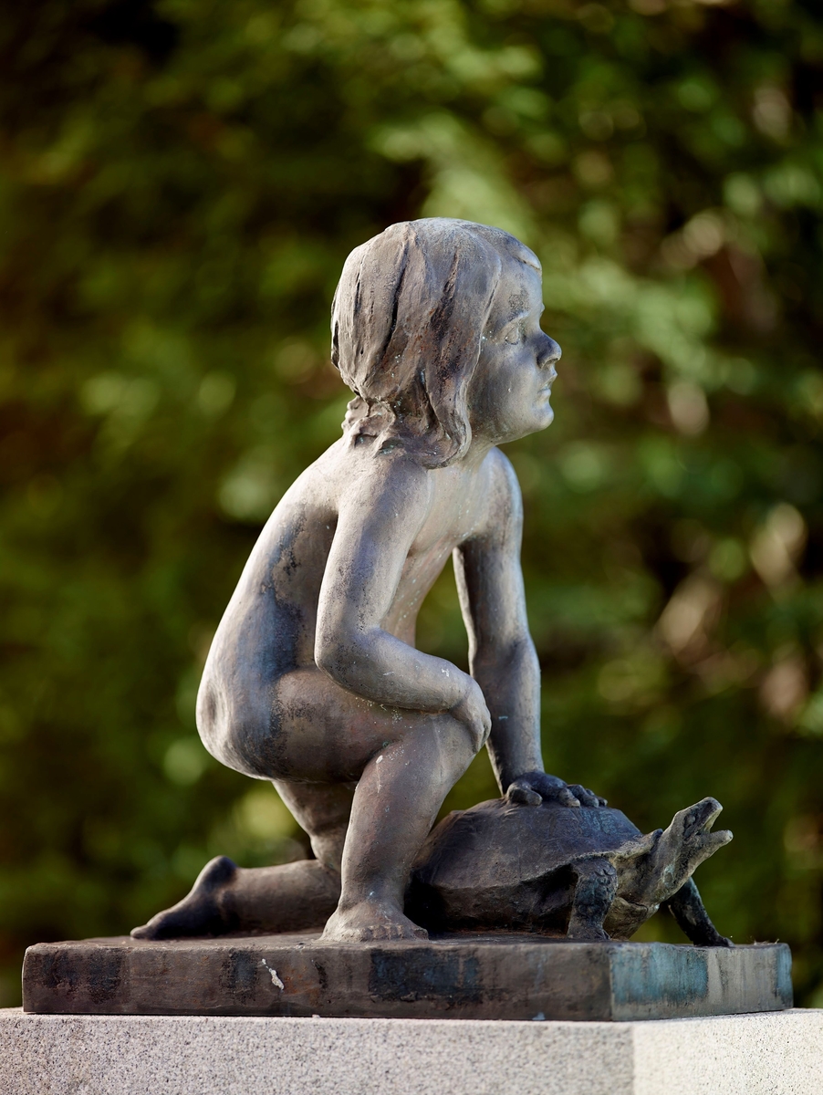 Støypt etter ASM 35 i gips. Dei to småjentene framfor Anders Svor Museum med and og skilpadde skulle stå på kvar si side av hovudgruppa Livskvinde (ASM 34) i eit fonteneanlegg. Bygartnaren gjorde i 1920 framlegg om å få reist anlegget på Valkyrie plass i Kristiania. Det førte ikkje fram.
Eva Engh, dotter av Svor sin naboven og hjelpar Isak Engh, sat modell for jenta på skilpadda.