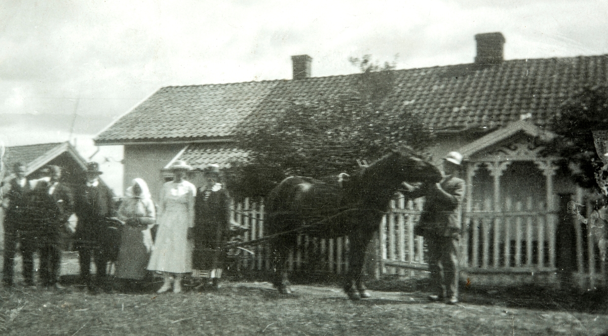 Gruppe ukjente står utenfor Plassen Engesletten (g.nr:195/3) i Løten. Hest og vogn.