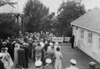 Grenna Hembygdsförenings ordförande A E Bolling talar i samband med Vitömuseets invigning. En stor folksamling står till vänster framför honom.