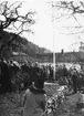 En folksamling på gården till Franckska gården där Andréemuseet invigs. En man hissar en flagga.