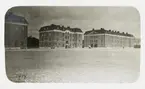 Vy över ett nybyggt (?) regemente en vintrig dag, 1914. 
Några meniga är på väg över kaserngården.'
Jfr HYCA1090.