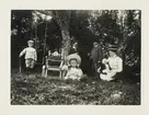 En familj poserar i en trädgård. Ca 1910.