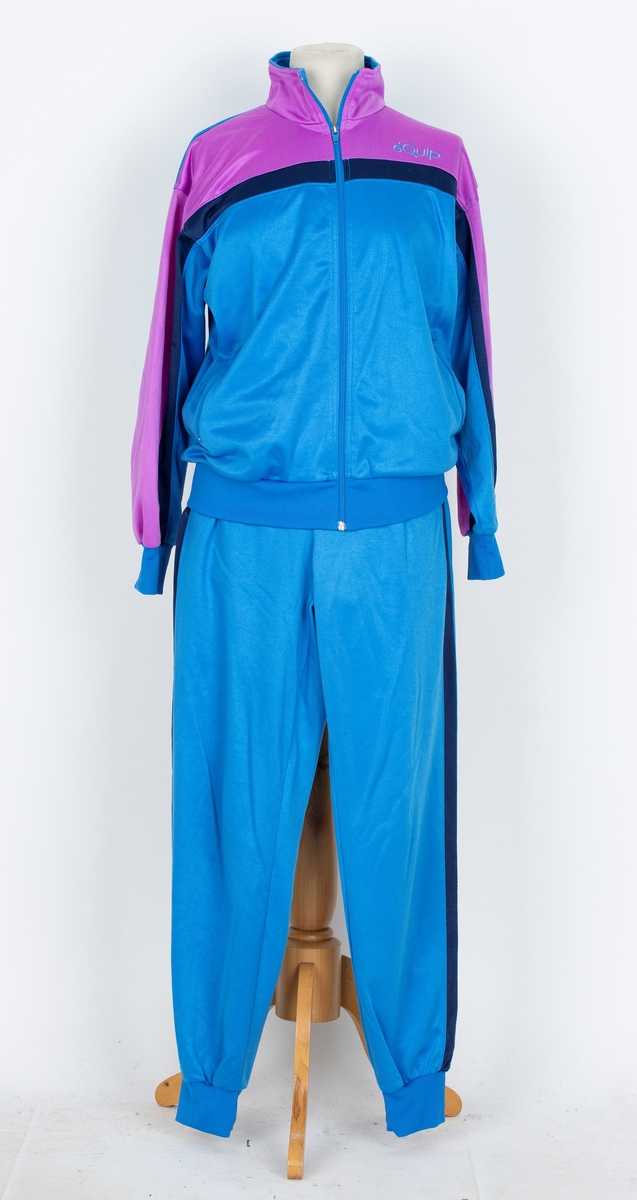 Joggedress. Lilla øverst, mørk blå stripe, blåturkis nederst.
A: jakke: Glidelås foran. Ståkrage.  
B: Bukse. Snor i livet, trikotmansjett nederst. mørk blå stripe i siden.

Kjøpt hos Wistex, Vestby.
Brukt undere sykehusopphold 1990 tallet. godt likt og mye brukt