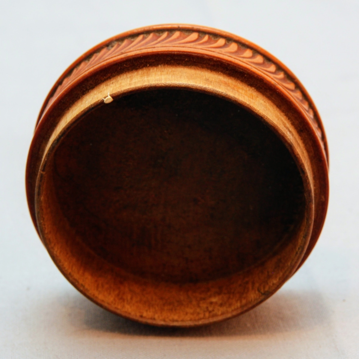 Svarvad rund ask i lackat trä. Med snidad dekor som täcker askens alla delar. Asken öppnas genom att ”delas” på mitten (består av två halvor som sammanfogas).  På askens ovansida föreställer dekoren ett fält där ändarna avslutas med bladdekor. I fältet är namnet ”Tilda” inristat. Bakom detta fält finns mer dekor föreställande blad. Dekoren på askens sidor består av lutande streck (som går i olika riktningar på de olika halvorna av asken). Asken har en rund yta med en svårtydd text i botten.