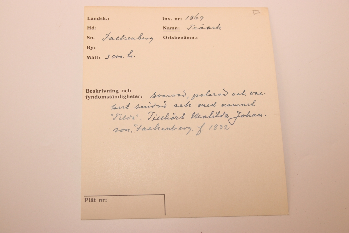 Svarvad rund ask i lackat trä. Med snidad dekor som täcker askens alla delar. Asken öppnas genom att ”delas” på mitten (består av två halvor som sammanfogas).  På askens ovansida föreställer dekoren ett fält där ändarna avslutas med bladdekor. I fältet är namnet ”Tilda” inristat. Bakom detta fält finns mer dekor föreställande blad. Dekoren på askens sidor består av lutande streck (som går i olika riktningar på de olika halvorna av asken). Asken har en rund yta med en svårtydd text i botten.