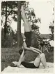 Två gymnastikflickor övar akrobatik på en gräsmatta. 1930-tal.