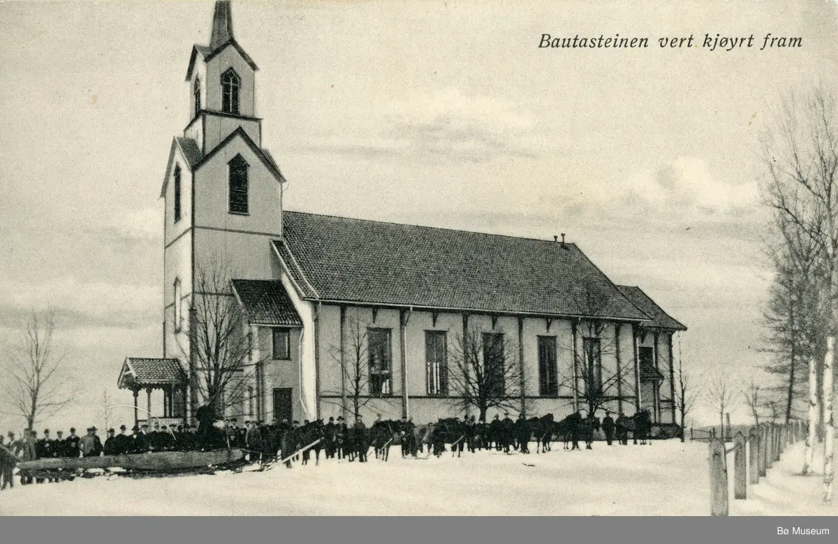 Bø kyrkje med folk og hestar som trekker ein stor bautastein.
