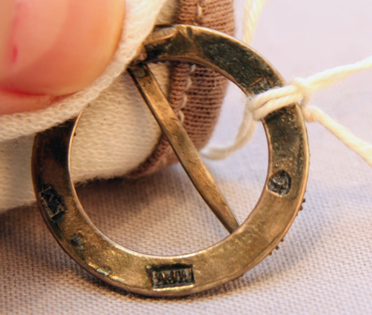 En oval ask av svept spån. Grönmålad, locket har röd kant, i mitten är en enkel ros målad. Äskan innehåller en fingerring, två mindre spännen, öronringar och ett litet hängsmycke i form av ett hjärta.