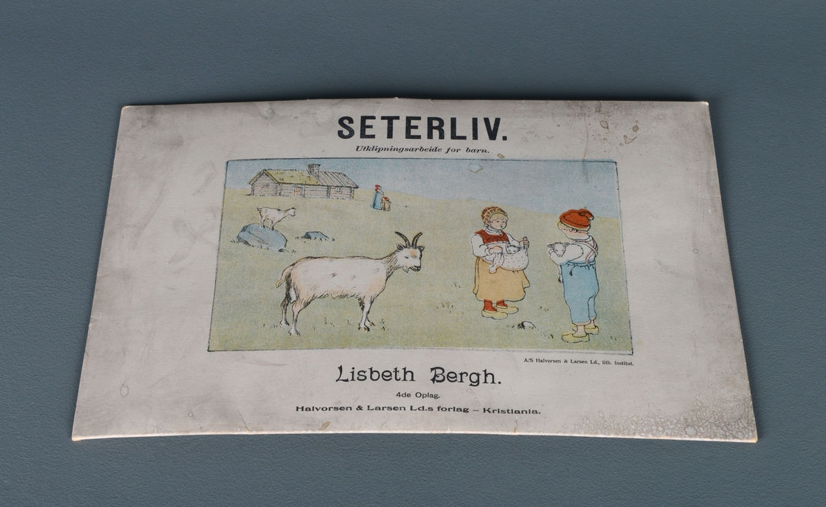 En mappe med utklipningasrbeid for barn. Mappen inneholder tre store ark av tykt papir/tynn kartong med påtrykte figurer som kan klippes ut. På det første arket kan man klippe ut geitene Rosisokka, Bjøllegeita, Duniblå, Knipla, Sølvitå og Vesle Sikke bæ. Man kan også klippe ut Ola som holder en killing, Kari som holder en kattunge og Marit som melker geita Dunidokka. På de to andre arkene kan man klippe ut de ulike delene til seterbygningen og lime dem sammen til et tredimensjonalt hus. Klippe- og limeanvisninger står trykt på arket. På den ene delen til baksiden av huset finenr man også geita Lukla. I mappen ligger det også et lite ark med noter og tekst til "Barna lokker paa gjetene sine". Til sist er det et postkort fra forlaget (ubrukt).