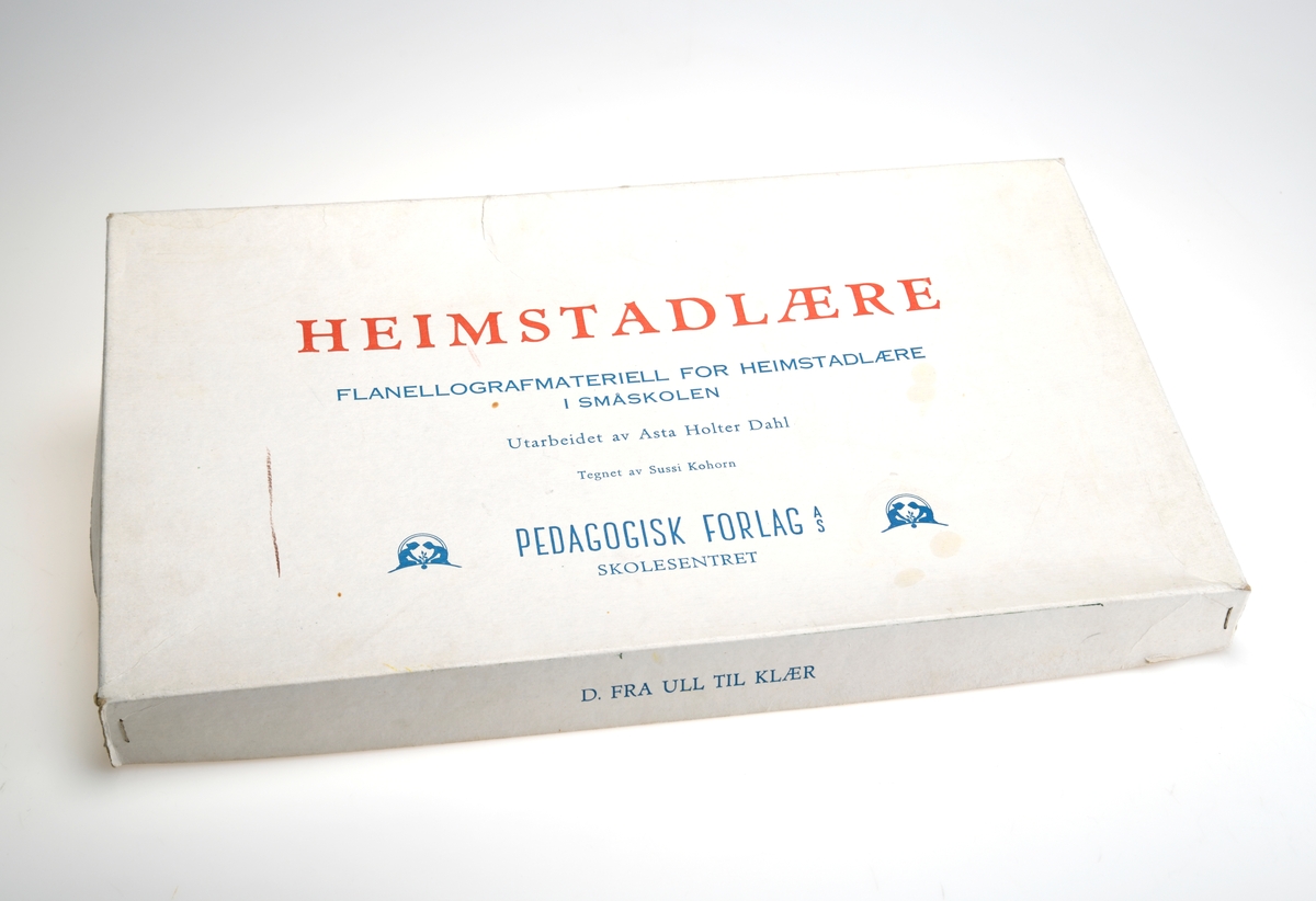 En eske med flanellografmateriell for heimstadlære i småskolen. Heimstadlære var et fag på skolen i perioden 1922 - 1974, og ble senere til Ortienteringsfag (O-fag). Esken er firkantet og har avtagbart lokk. Lokket er stiftet sammen. I esken ligger det ulike figurer som er merket D og med et nummer. Tema for denne esken er "Fra ull til klær". Det er formskårne figurer som viser sau med ull, klipping av sau, karding og spinnign av ull og til slutt veving. 4 figurer viser redskap man trenger til dette: sauesaks, karde, håndtein og vevskyttel. En gruppe figurer viser hva man kan lage fra ull (garnnøste, strikketøy, genser, tekstil og så videre). Det er også inetriørfigurer som vindu med gardiner, bord med kaffestell og en stol. Ialt er det 23 deler.
Alle figurene har en type filt på baksiden slik at de kan festes på en flanellograf.