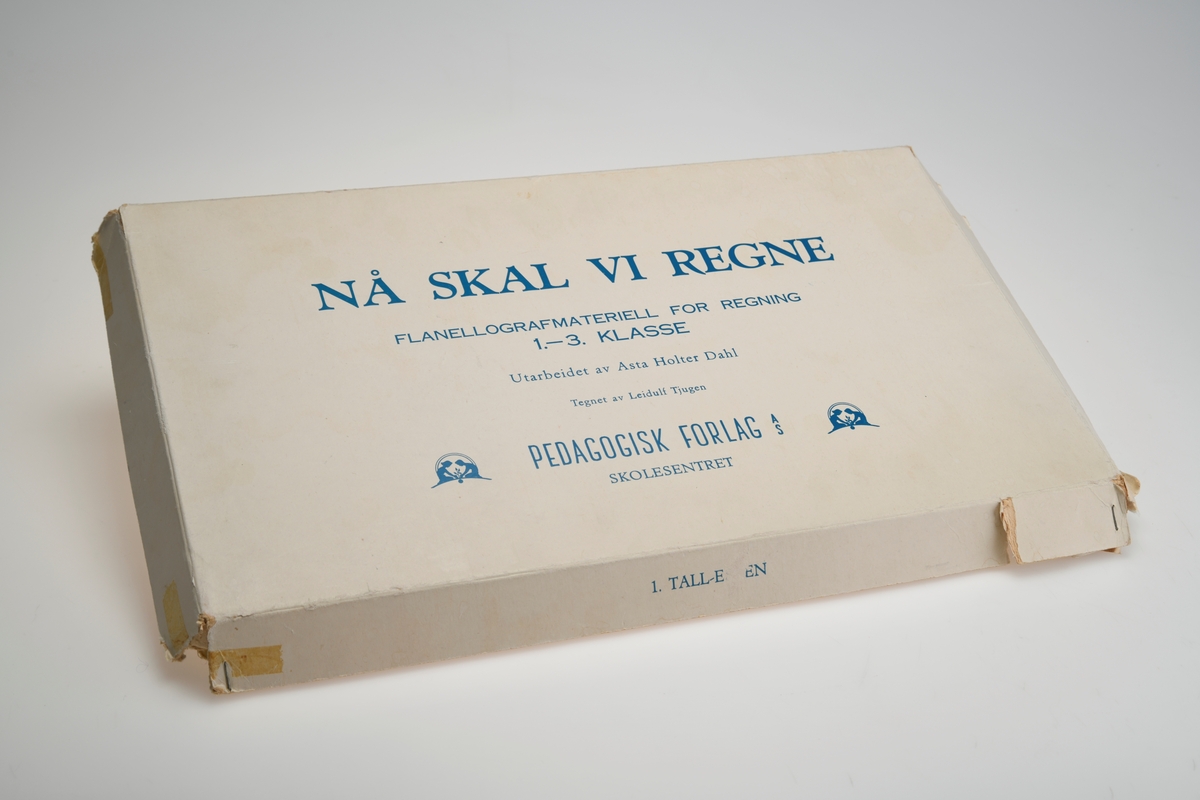 En eske med flanellografmateriell for regning beregnet på elever i 1. - 3.klassetrinn. Esken er firkantet og har avtagbart lokk. Lokket er stiftet sammen. Esken er delt inn i 12 rom, og i hvert rom ligger det ulike figurer. Figurene skal forestille katt, blomst, fisk, kongle, lastebil, sommerfugl, julenisse, jente, ugle, rev og ekorn. I det siste rommet er det utklippede rundinger og streker i ulike størrelser. Alle figurene har en type filt på baksiden slik at de kan festes på en flanellograf.