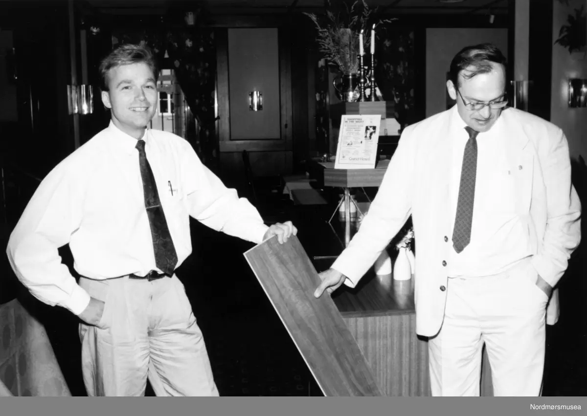 John Arild Birkeland og Marius Fostervold. Grand Hotell, viser frem ny parkett.
Bildet er fra avisa Tidens Krav sitt arkiv i tidsrommet 1970-1994. Nå i Nordmøre museums fotosamling.