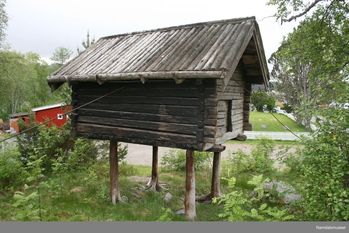 Stabbur som står på fire naturlig vokste rotstokker, ca. 130 cm over bakken.