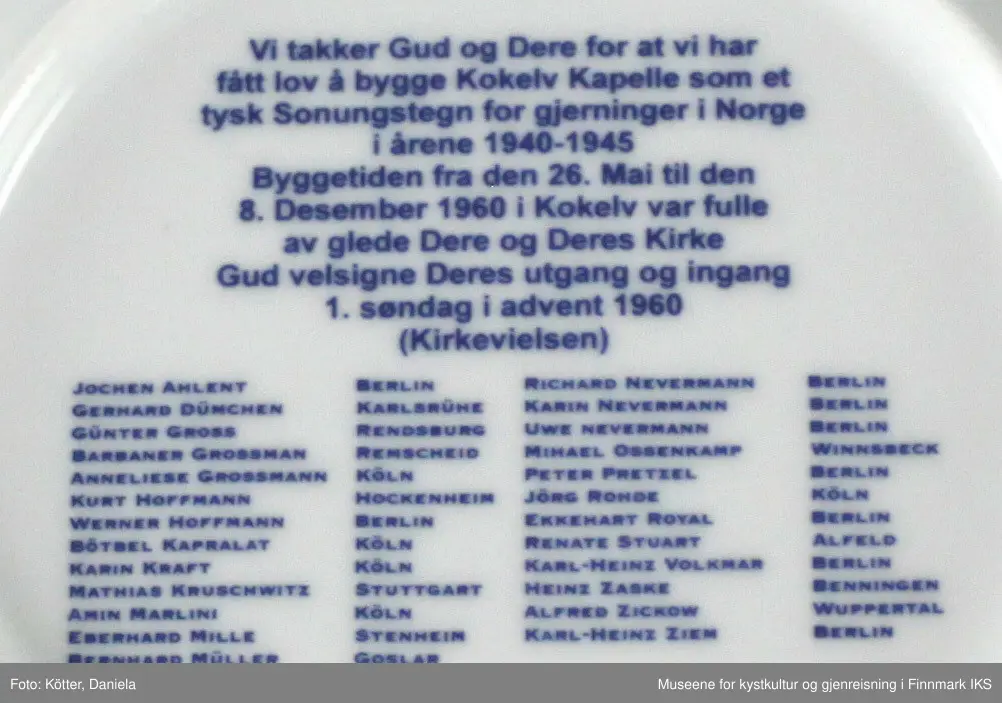 Den hvite porselenstallerken med motiv i blått er en minnegjenstand som ble produsert i anledning bygging av kirken i Kokelv i Finnmark. Kirka ble bygget i 1960 av medlemmer i foreningen Aksjon Soningstegn Fredstjeneste som "et bønn om tilgivelse og fred", som det heter i foreningens stiftelsestekst.  

På tallerkens forside er det avbildet en tegning av Kokelv Kirke. Navnet står oppe til venstre. Under tegninga finnes det foreningens symbol og en tekst. På baksida er det oppført Navn til alle som har vært med og hvor de kommer ifra.  På baksiden er det laget to hull for å kunne henge tallerken opp som en minne- eller pyntegjenstand.

Tallerken er innpakket i originalemballasjen, en pappeske med blått og hvitt dekor. 