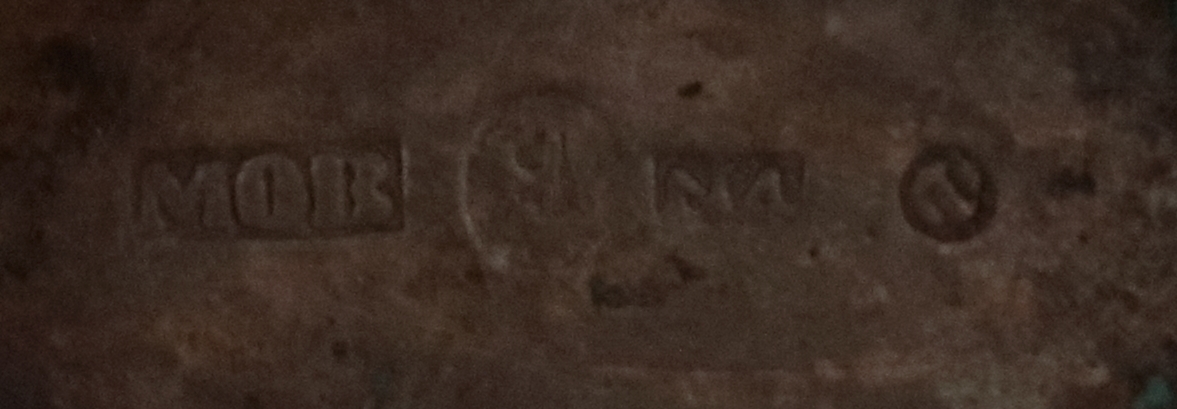 Oval dosa av silver. Med ett lock med gångjärn. Ytterkanten på ovansidan av locket har en cisilerad bård av stiliserade blad. I mitten av locket står initialerna "B. S. D. " och "G. A. S." . Asken är stämplad på insidan av botten med bokstäverna "MOB" (Michael Olof Barkman,1813-1851, Varberg) och med "N4" (år 1843) samt två svårtydda stämplar.