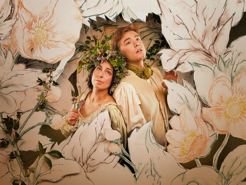 En mann og en dame omringet av blomsterkulisser