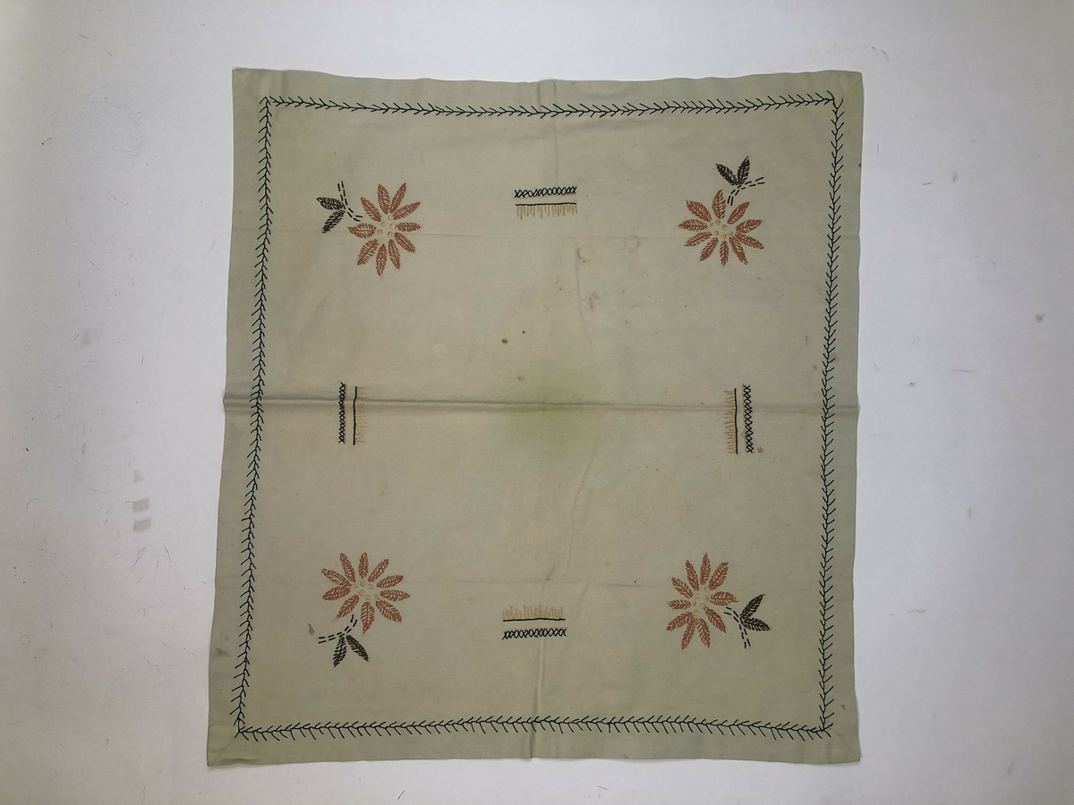 Liten, kvadratisk duk brodert med stiliserte blomster. Trolig fra 1940-tallet.
