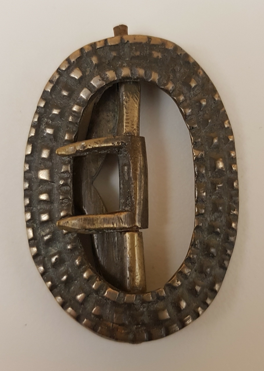 Sex spännen av mässing, järn eller vitmetall, delvis defekta.

Från Dalsland.