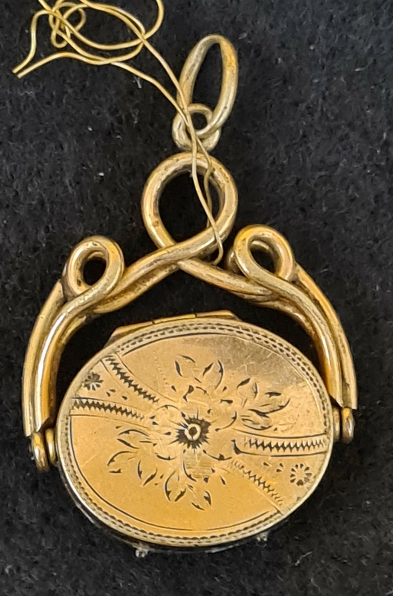 1. Avlång berlock (medaljong) med frimurarsymbol på baksidan. L. 2,9 cm. B. 2 cm.

2. Oval medaljong, troligtvis silver.Röd sten.  L. 2,7 cm  B. 2,4 cm