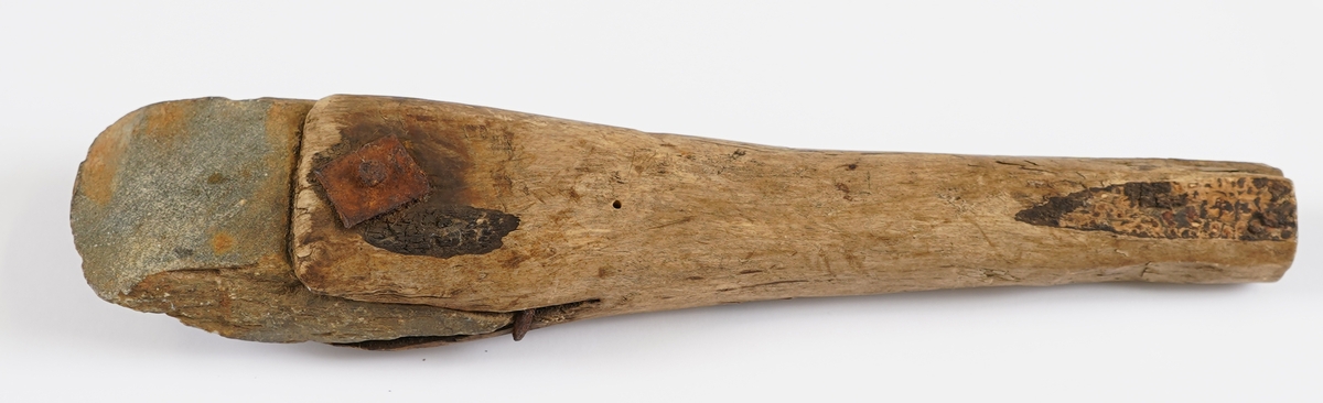 Bryne av natutstein montert i trehandtak.