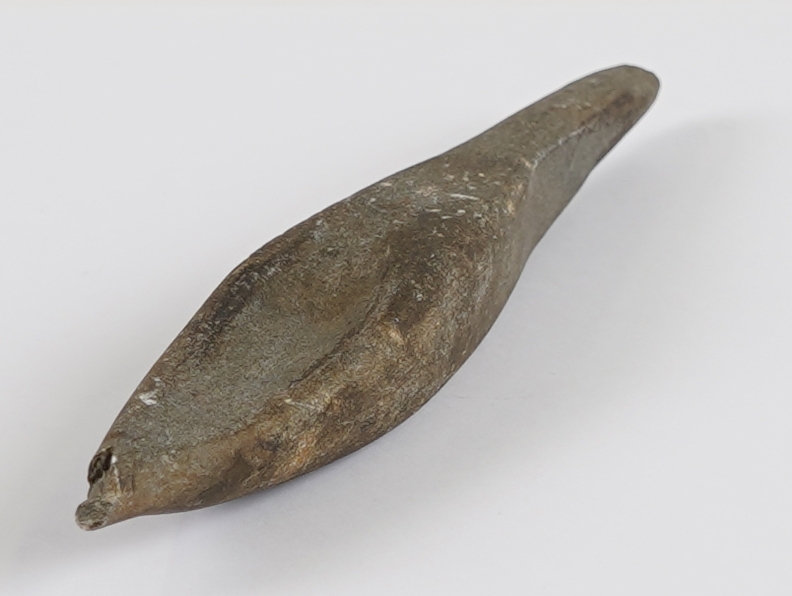 Form: Tilnærma kvadratisk snitt, men med grop på eine sida og rundt snitt i tilspissinga mot eine enden (avbroten spiss).