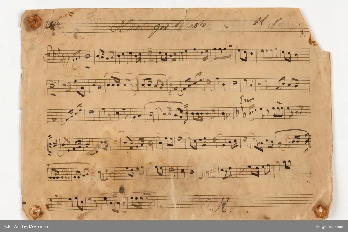 Håndskrevne noteark til "Hardanger marsj ". Det er seks noteark i med noter til forskjellige instrumenter. Arkene er trykt med notelinjer, mens notene er håndskrevne.