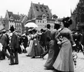 Skioptikonbild med motiv av stadsvimmel på torget i Nürnberg vid Frauenkirche.
Bilden har förvarats i kartong märkt: Nürnberg VI. 1901