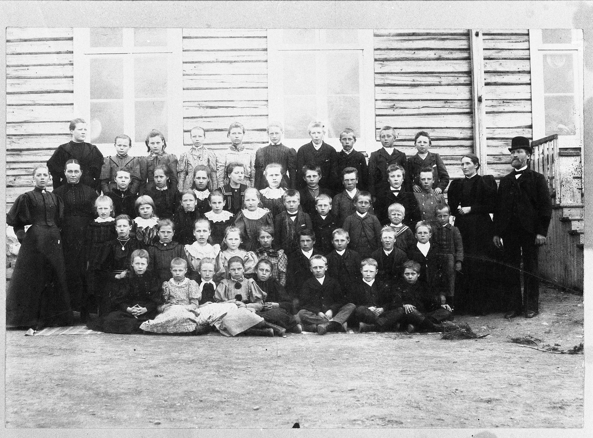 Skolebilde fra Fagernes skole i Totenvika ca. 1894-96. Ca. halvparten av elevene og lærere oppstilt foran tømmerbygningen.
Første rekke, fem jenter og to gutter sitter: 1.Nelly Aaarsby (g.m. Albert Hveem), 2.Hilda Hermanrud (dtr. av Gustav, reinste til USA), 3.Agnes Kallykkjen (g.m. Hans Bjørnstad), 4.Ukjent, 5.Petra Nilsen (g.m. Hans Pannengstuen), 6.Ukjent, 7.Magnus Flenes?.
Andre rekke (står på knær, fem jenter og fire gutter): 1-5.Ukjente, 6.Even Liberg (f.1879), 7-8.Ukjente, 9.Martin Løkkebakken (trolig tvillingbror til Magnus Flenes).
Tredje rekke (fem jenter og fem gutter): 1.Ukjent, 2.Palma Wedøe (g.Pettersenm, f.1888), 3.Marianne Kalløkken (til USA, men kom tilbake. Gift Nikkerud), 4.Ukjent, 5.Klara Petersen (dtr. til lærer Petersen), 6-7.Ukjente, 8.Arne Aarsby (f.1888, reiste til USA, men kom tilbake), 9.Hjalmar Wedøe (til USA), 10.Marius Aarsby (f.1890).
Fjerde rekke (fem jenter og fire gutter): 1.Jenny Oppegaard (f.1883, g.m.Mads Aarsby), 2.Ukjent, 3.Mina Sannerud, 4.Jenny Wedøe (til USA), 5.Karen (?) Rundhaugen?, 6.Martin Markeng, 7.Halfred Gotlandshaugen, 8.Ole Haugland?, 9.Johan Aarsbyengen (kalte seg senere Aarsby).
Femte rekke (bakerst står fem jenter og fire gutter): 1-4.Ukjente, 5.Olga Fjelstad (g.m. Johs. Brubakken, skilt, til USA, men kom tilbake), 6.Petter Olsen?, 7.Ukjent, 8.Mads Aarsby (f.1884), 9.Ukjent.
Til venstre står lærerinne Hanna Hansen, og ved hennes side Mina Aarsby (f.Reinsby). Bak disse står datter av læreren, Kristine (kalt Kikka) Petersen. Helt til høyre står lærer Elisæus Petersen, og ved hans side kona Kristiane Petersen. Paret hadde fem barn.