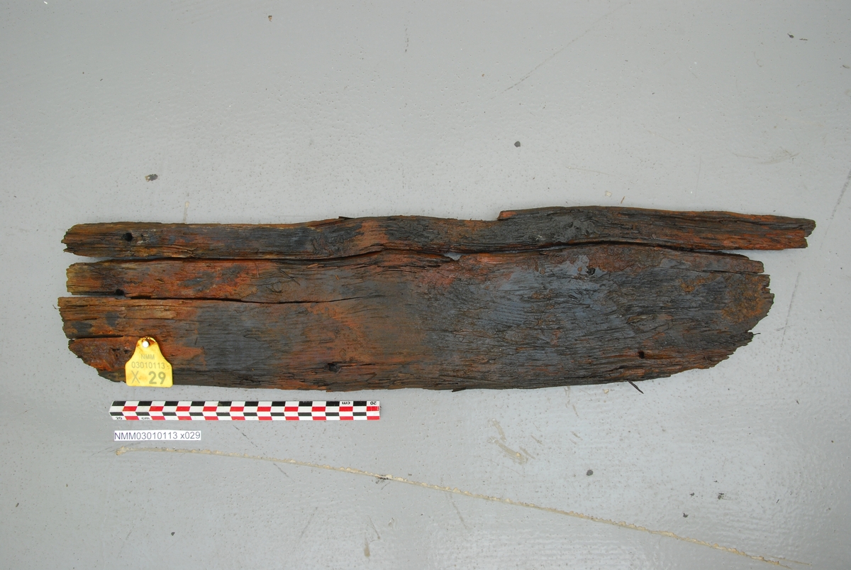 Hudbordfragment. Brudd i ene enden. Liten skaring i den andre. Mulig reparasjonsbord til X015.