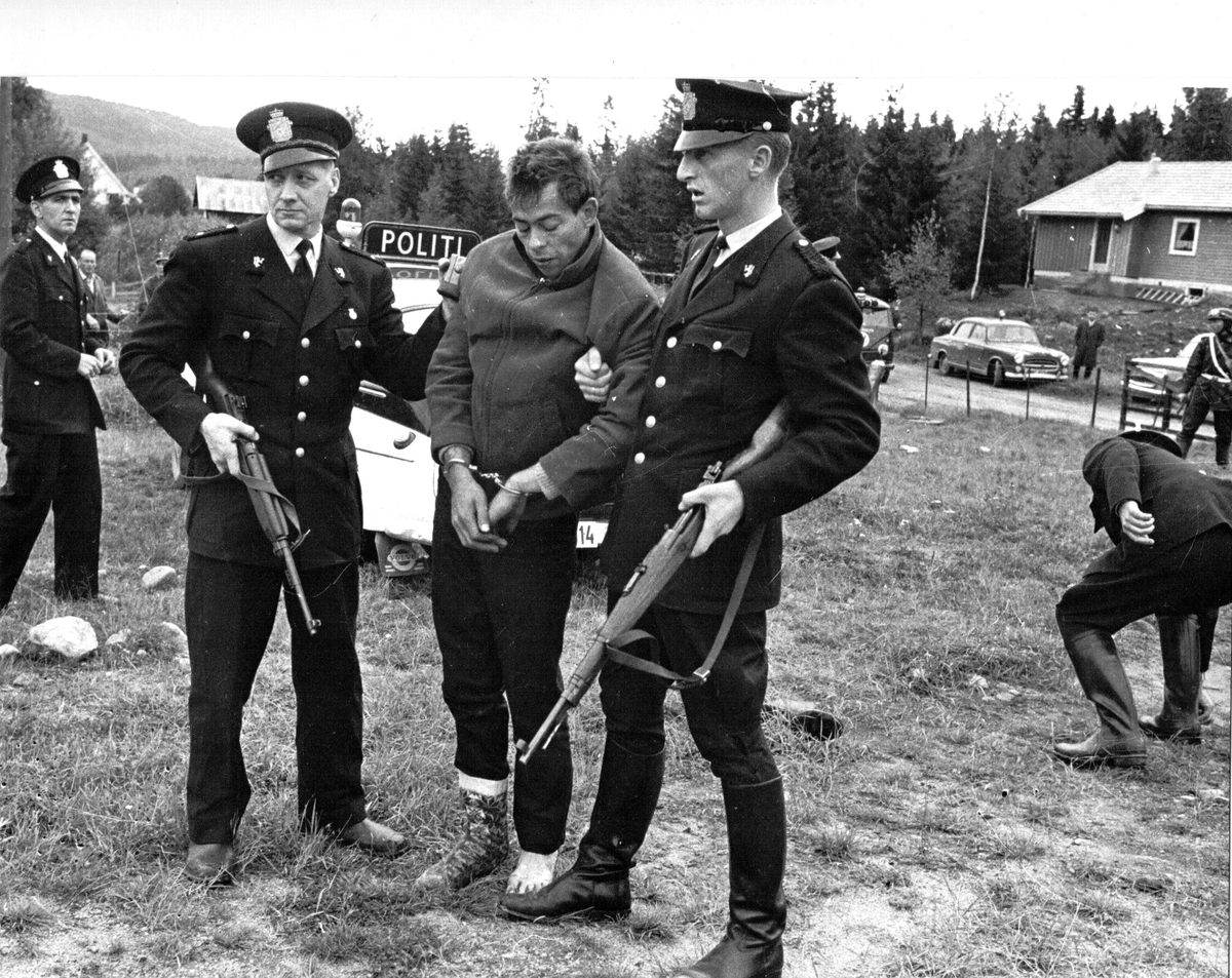 To bevæpnede politimenn med arrestant.