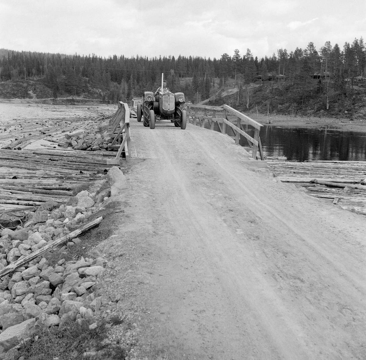 Traktor på bru i Søre Osen, Trysil, Hedmark. Bildet er tatt lengst sør i Osensjøen, ved Sjøenden i overgangen til Vesle Ossjøen. Traktorføreren heter Odd Magne Larsen.