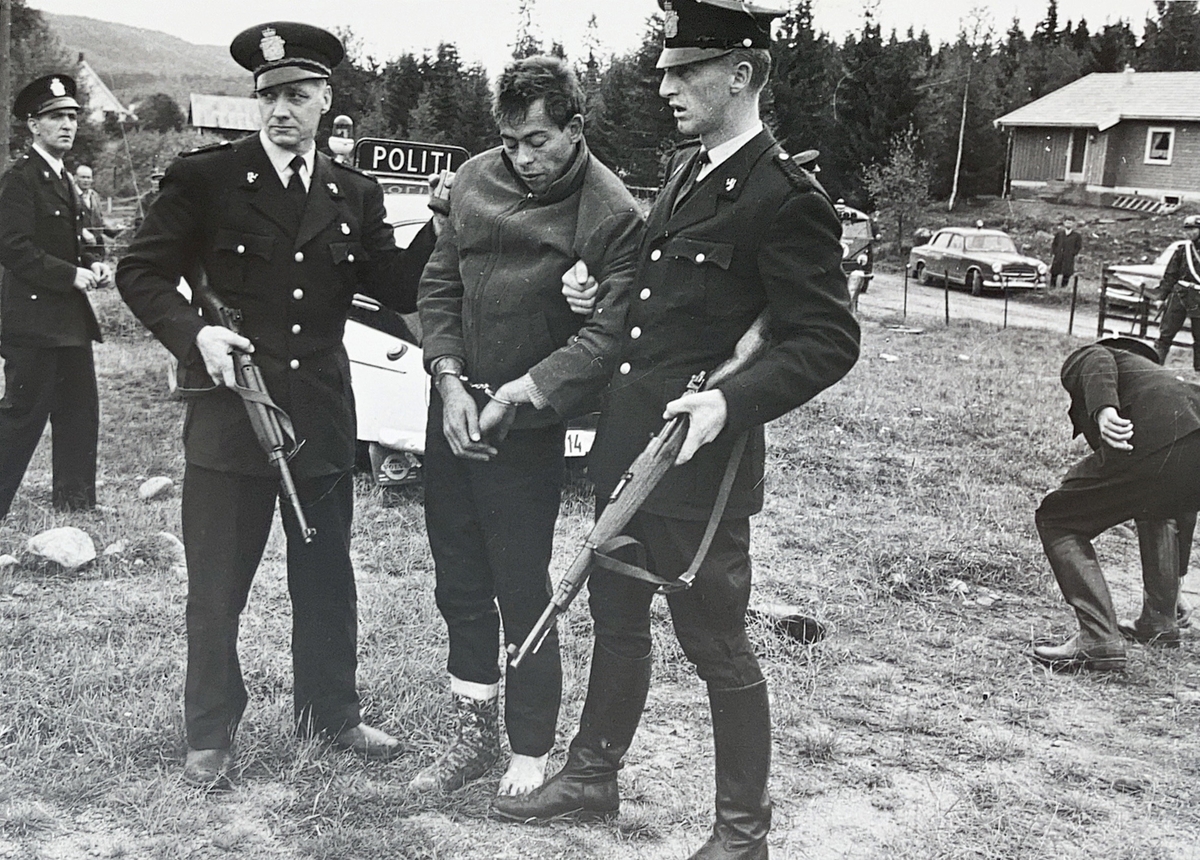 To bevæpnede politimenn med arrestant.