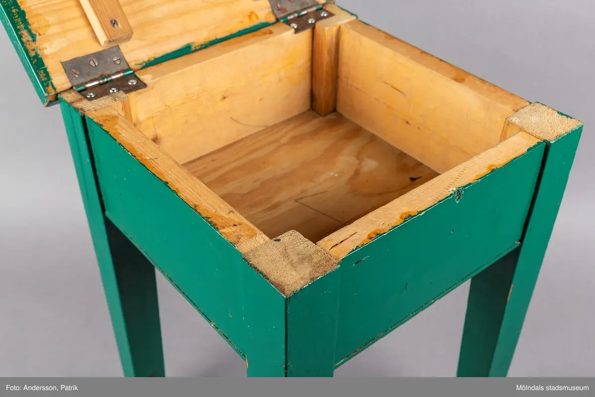 Grön sängpall/sängbord med förvaring. Pallen är 43 centimeter hög och 30 centmeter bred. Den är tillverkad i trä och målad i mörkgrönt. 

Gåva: Föreningen Gåreviks Barnkoloni. Pallen har stått i sovsalen. Varje barn hade en pall vid sin säng, som de kunde förvara sina privata tillhörigheter i.