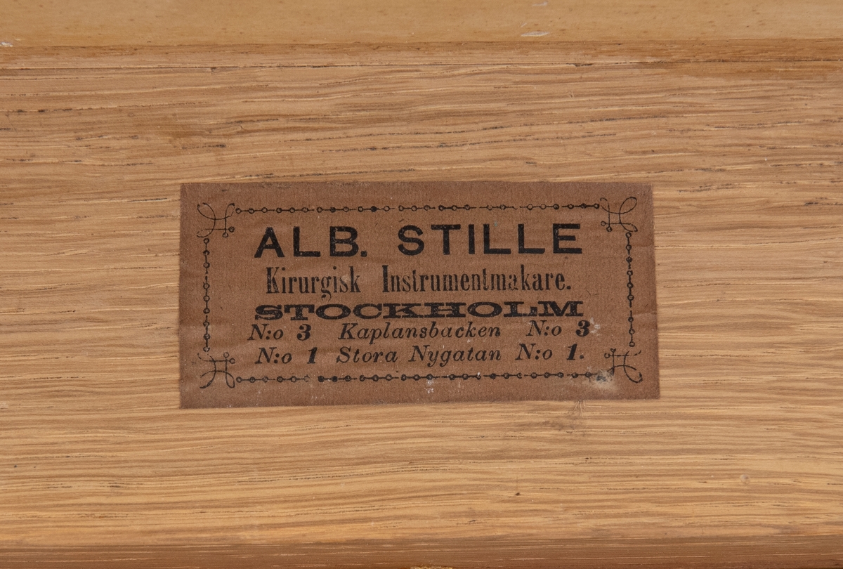 Sjukvårdslåda av trä (:1) med textilfodral (:2), nyckel (:3) och innehåll (:4-33). Locket stängs med gångjärn, haspar och nyckel. Metallskodda hörn, handtag på lådans kortsidor. Locket märkt "3DJE TRDT NO 8". På insidan av locket finns märke från tillverkaren ALB. STILLE. Textilfodralet stängs med läderremmar och metallspännen, hål på sidorna för handtagen.
Sjukvårdslådan innehåller en avlång trälåda (:4) med en såg (:5), fem knivar (:6-10), två krokar (:11-12) och tre tänger (:13-15). 
En till mindre trälåda (:16) med utrustning för koppning (:17-22). 
En trälåda utan lock (:23) med en spruta (:24), skruvtourniquet av sadelgjord med kuddar klädda med rött sämskskinn (:25) och nålförvaring (:26-29). 
En mindre svart läderväska innehållande bland annat tänger och skalpeller (:30).
Ett svart fodral med innehåll (:31).
Rem med kuddar klädda med rött sämskskinn (:32).
Spruta av metall (:33).