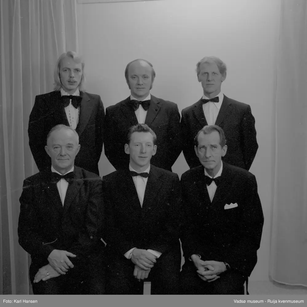 Styret i Vadsø Mannsangforening i november 1976.
Bak fra venstre; Lars Rødsand, Rolf Olsen, Bjarne Feldt. 
Foran fra venstre; Eilif Olsen, Aage Noren og Per W Christensen.
Kilde: VAM.F01_000696