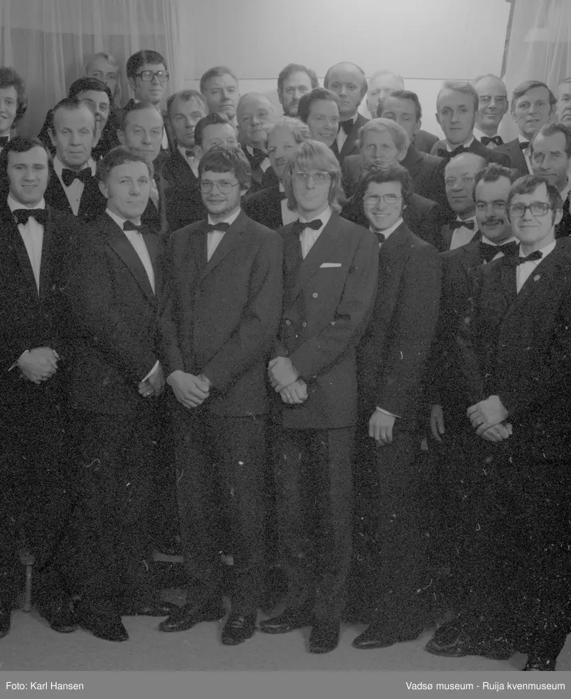 Vadsø mannsangforening i november 1976. På bildet ser vi nr 1 Terje Andersen, nr 2 Bjarne Johnsen, nr 3 Trygve Aronsen, nr 4 Kåre Johansen, nr 5 Lars Rødsand, nr 6 Sigmund Solli, nr 7 Rudolf Korbi, nr 8 Ernst Hansen, nr 9 Sigurd Pedersen, nr 10 Åge Noren, nr 11 Arve Hjelde, nr 12, Tor Falck?, nr 13 Eilif Olsen, nr 14 Sture Nygård, nr 15 Otto Hoel, nr 16 Jan Iver Ingebrigtsen, nr 17 Olav Grøttum, nr 18 Rolf Olsen, nr 19 ukjent, nr 20 Bjarne Feldt, nr 21 Leif Nystrøm. nr 22 Rolf Skille, nr 23 Birger Berg, nr 24 Ragnvald Store, nr 25 Nils Smistad, nr 26 Hans Iversen, nr 27 Birger Johnsen, nr 28 Per W. Christensen, nr 30 Sigmund Hansen, nr 31 Håkon Sæther
Kilde: VAM. F01_000697