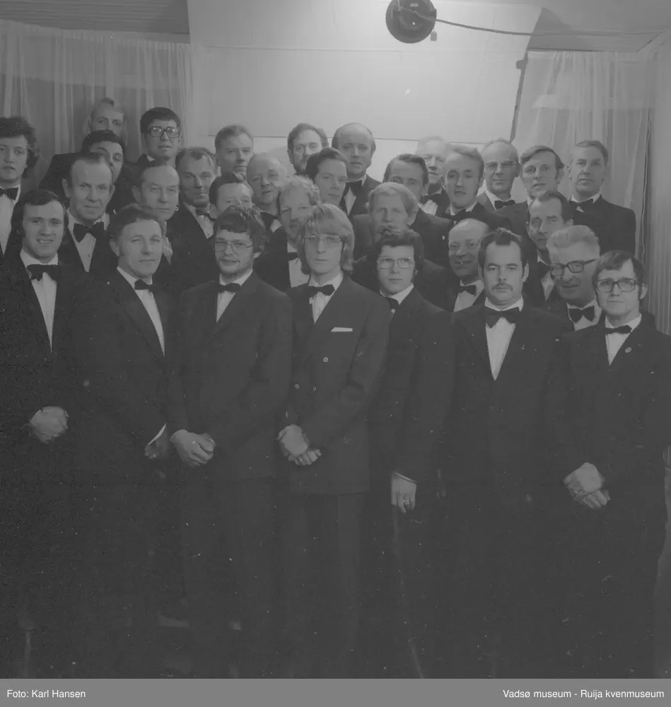 Vadsø mannsangforening, november 1976. På bildet ser vi nr 1 Terje Andersen, nr 2 Bjarne Johnsen, nr 3 Trygve Aronsen, nr 4 Kåre Johansen, nr 5 Lars Rødsand, nr 6 Sigmund Solli, nr 7 Rudolf Korbi, nr 8 Ernst Hansen, nr 9 Sigurd Pedersen, nr 10 Åge Noren, nr 11 Arve Hjelde, nr 12, Tor Falck?, nr 13 Eilif Olsen, nr 14 Sture Nygård, nr 15 Otto Hoel, nr 16 Jan Iver Ingebrigtsen, nr 17 Olav Grøttum, nr 18 Rolf Olsen, nr 19 ukjent, nr 20 Bjarne Feldt, nr 21 Leif Nystrøm. nr 22 Rolf Skille, nr 23 Birger Berg, nr 24 Ragnvald Store, nr 25 Nils Smistad, nr 26 Hans Iversen, nr 27 Birger Johnsen, nr 28 Per W. Christensen, nr 29 Finn Aanstad, nr 30 Sigmund Hansen, nr 31 Håkon Sæther
Kilde: VAM.F01_000697 