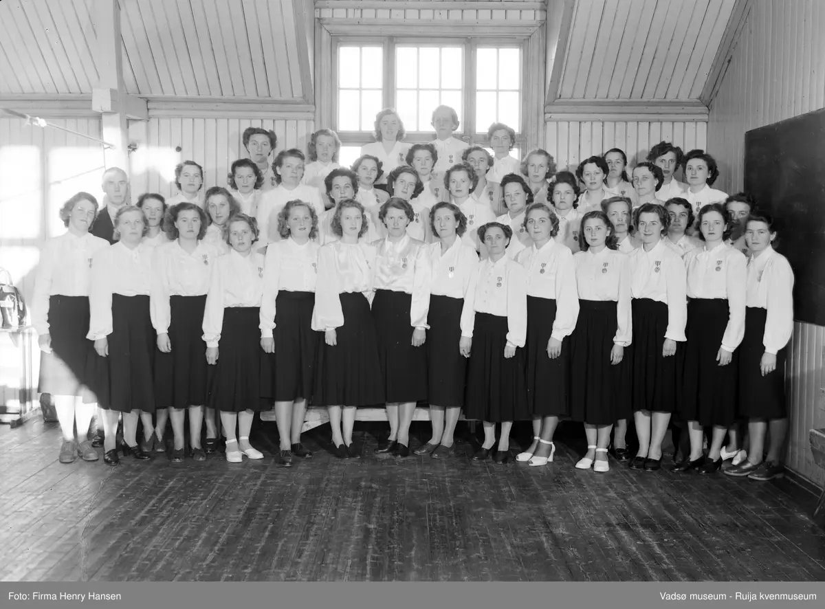 Vadsø Damekor 1950. Damekoret er samlet i 2.etasje på den gamle gymnastikksalen i Vadsø.
Kormedlemmer; 1 Mary Bohinen, 2 dirigent Lunde, 3 Elsa Wærnes, 4 Reidun Basma, 5 Amy Evanger, 6 Alfhild Ballo, 7 Alma Seppelæ, 8 Ragny Stock, 9 Lisbeth Esbensen, 10 Martha Hansen, 11 ukjent, 12 Mimi Zahl (Jørgensen), 13 Fru Hamborg Olsen,  14 ukjent, 15 Gerda Hoftaniska, 16 Fru (Feldt) Bjerke, 17 Karin Wærnes, 18 Ellen Helfjord, 19 Ruth Hågensen, 20 Borghild Dahl, 21 Ågot Lohiniva, 22 Fru Bohinen,  23 Hulda Onseng, 24 Klara Pedersen, 25 Torbjørg Vorren, 26 Astrid Brevik, 27 Ella Hoftaniska,  28 Bella Stock, 29 Ingrid Klemetsen, 30 Frk Eriksen, 31 Fru Haldorsen, 32 Johanna Schjetne, 33 Ruth Helfjord, 34 Sofie Klemetsen, 35 Elsa Schirnov, 36 Asbjørg Betten, 37 ukjent, 38 Randi Helander, 29 Pauline Stock, 40, Fru Aronsen, 41 ukjent, 42 Mimmi Dallavara