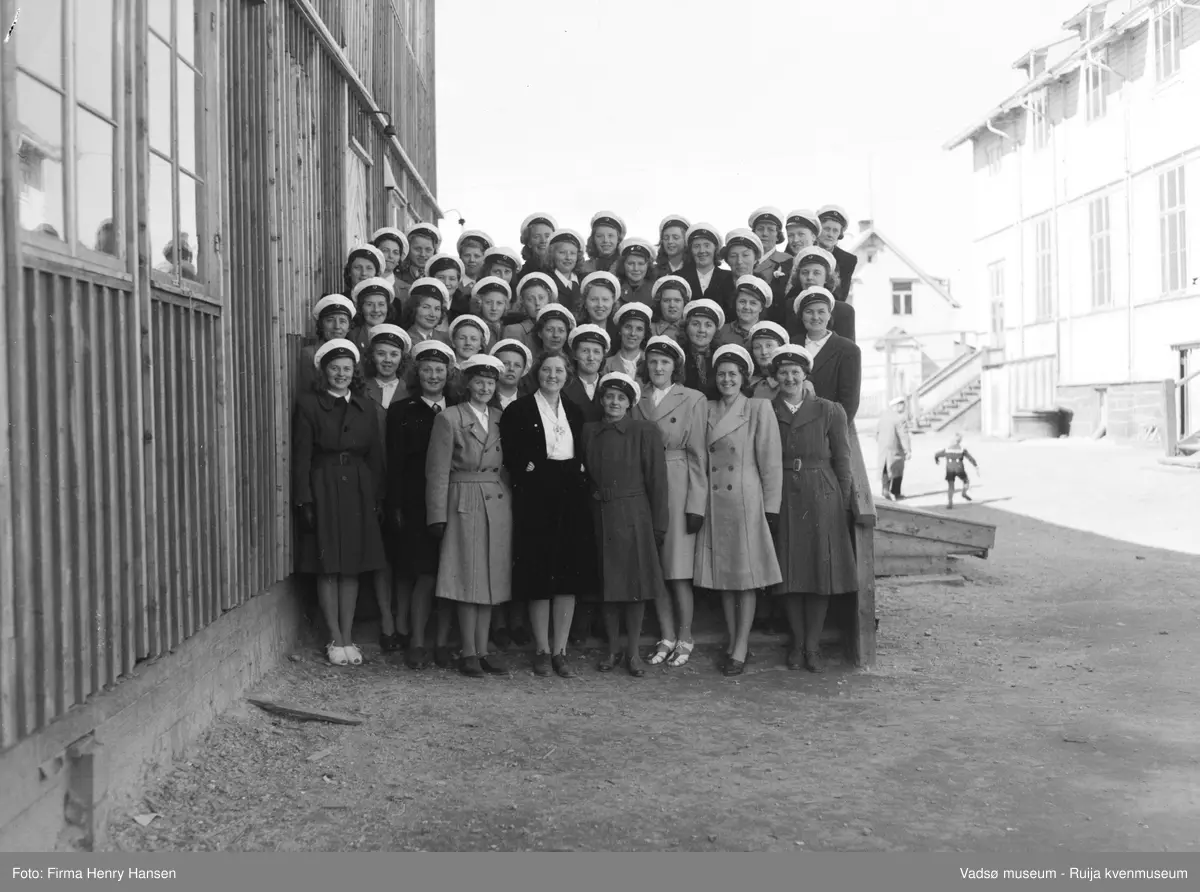 Vadsø Damekor 1951/1952. Damekoret er samlet på skoleplassen ved Skolebrakka. Til høyre i bildet ligger Gymnastikksalen.
Kormedlemmer: 1 Ågot Lohiniva, 2 Ingrid Klemetsen, 3 Ukjent, 4 Anny A. Pedersen, 5 Ruth Helfjord, 6 Liv Johnsen, 7 Ukjent, 8 ? Haldorsen, 9 Frida Gundersen, 10 Alma Saxi, 11 Ukjent, 12 Astrid Brevik, 13 Johanna Schjetne, 14 Sofie Klemetsen, 15 ? Schjetne, 16 Asbjørg Betten, 17 ? Hildonen, 18 Kari Svendsen, 19 Ukjent, 20 Arna Helgesen, 21 Klara Pedersen, 22 Randi P. Helander, 23 Irene Methi Angel, 24 Ukjent, 25 Ellen Helfjord, 26 Fru Hamborg Olsen, 27 Pauline Stock, 28  Martha Hansen, 29 Lisbeth Methi, 30 Reidun Methi, 31 Ukjent, 32 Ruth Johannessen, 33 Aslaug Methi Karlsen, 34 Alma Seppelæ, 35 Reidun Basma Pedersen, 36 Ukjent, 37 Ukjent, 38 Amy Evanger, 39 Borghild Dahl, 40, Torbjørg Vorren, 41 Lisbeth Esbensen, 42 Gudrun Evanger
