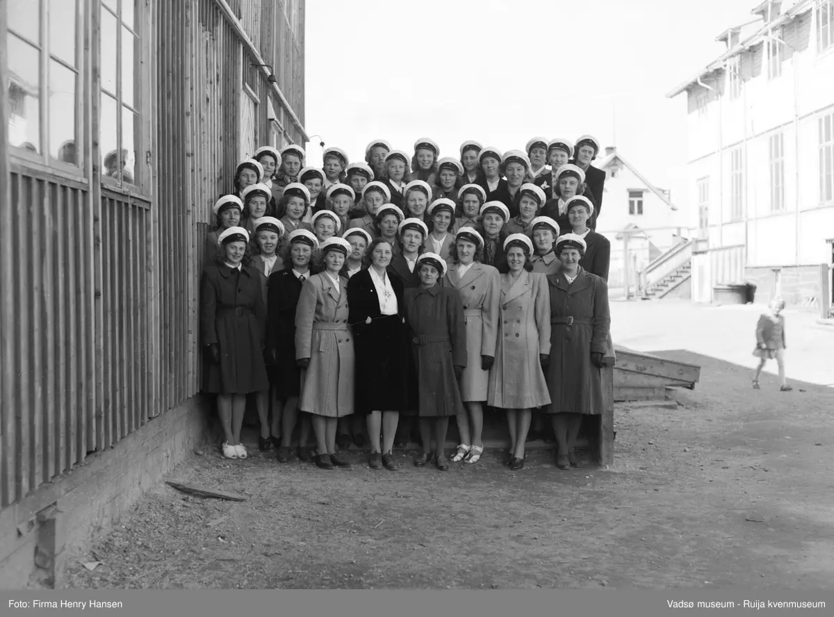 Vadsø Damekor 1951/1952. Damekoret er samlet på skoleplassen ved Skolebrakka. Til høyre i bildet ligger Gymnastikksalen.
Kormedlemmer: 1 Ågot Lohiniva, 2 Ingrid Klemetsen, 3 Ukjent, 4 Anny A. Pedersen, 5 Ruth Helfjord, 6 Liv Johnsen, 7 Ukjent, 8 ? Haldorsen, 9 Frida Gundersen, 10 Alma Saxi, 11 Ukjent, 12 Astrid Brevik, 13 Johanna Schjetne, 14 Sofie Klemetsen, 15 ? Schjetne, 16 Asbjørg Betten, 17 ? Hildonen, 18 Kari Svendsen, 19 Ukjent, 20 Arna Helgesen, 21 Klara Pedersen, 22 Randi P. Helander, 23 Irene Methi Angel, 24 Ukjent, 25 Ellen Helfjord, 26 Fru Hamborg Olsen, 27 Pauline Stock, 28  Martha Hansen, 29 Lisbeth Methi, 30 Reidun Methi, 31 Ukjent, 32 Ruth Johannessen, 33 Aslaug Methi Karlsen, 34 Alma Seppelæ, 35 Reidun Basma Pedersen, 36 Ukjent, 37 Ukjent, 38 Amy Evanger, 39 Borghild Dahl, 40 Torbjørg Vorren, 41 Lisbeth Esbensen, 42 Gudrun Evanger