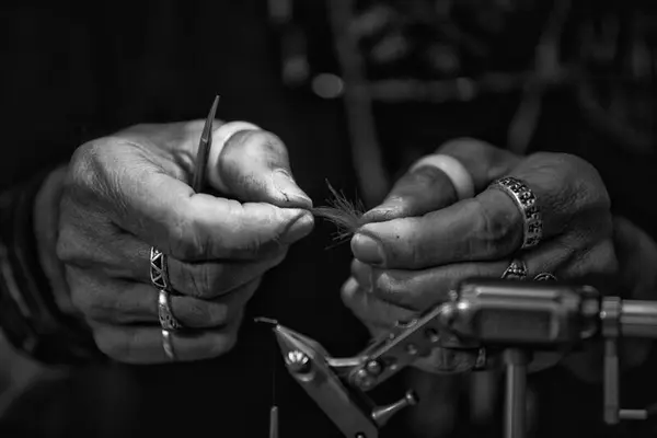 Bilde av to hender som binder fluer