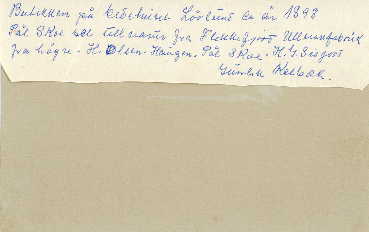 "Paul (Pål) Skoe sel ullvarer frå Flekkefjord Ullvarefabrikk. Frå v. Gunlek H. Kalbekk el. Moen, Halvor G. Sisjord, Pål Skoe og H. Olsen Haugen." (Skrive av Ingeborg H. Sisjord).  
Bildet er tatt utanfor den gamle landhandelen bygd av T. Tovsen på Løvlund

